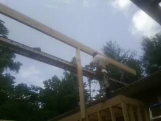 Carpenter setting a ridge beam over a new addition frame — Ice Dam Removal by Roofing Brothers in Flourtown