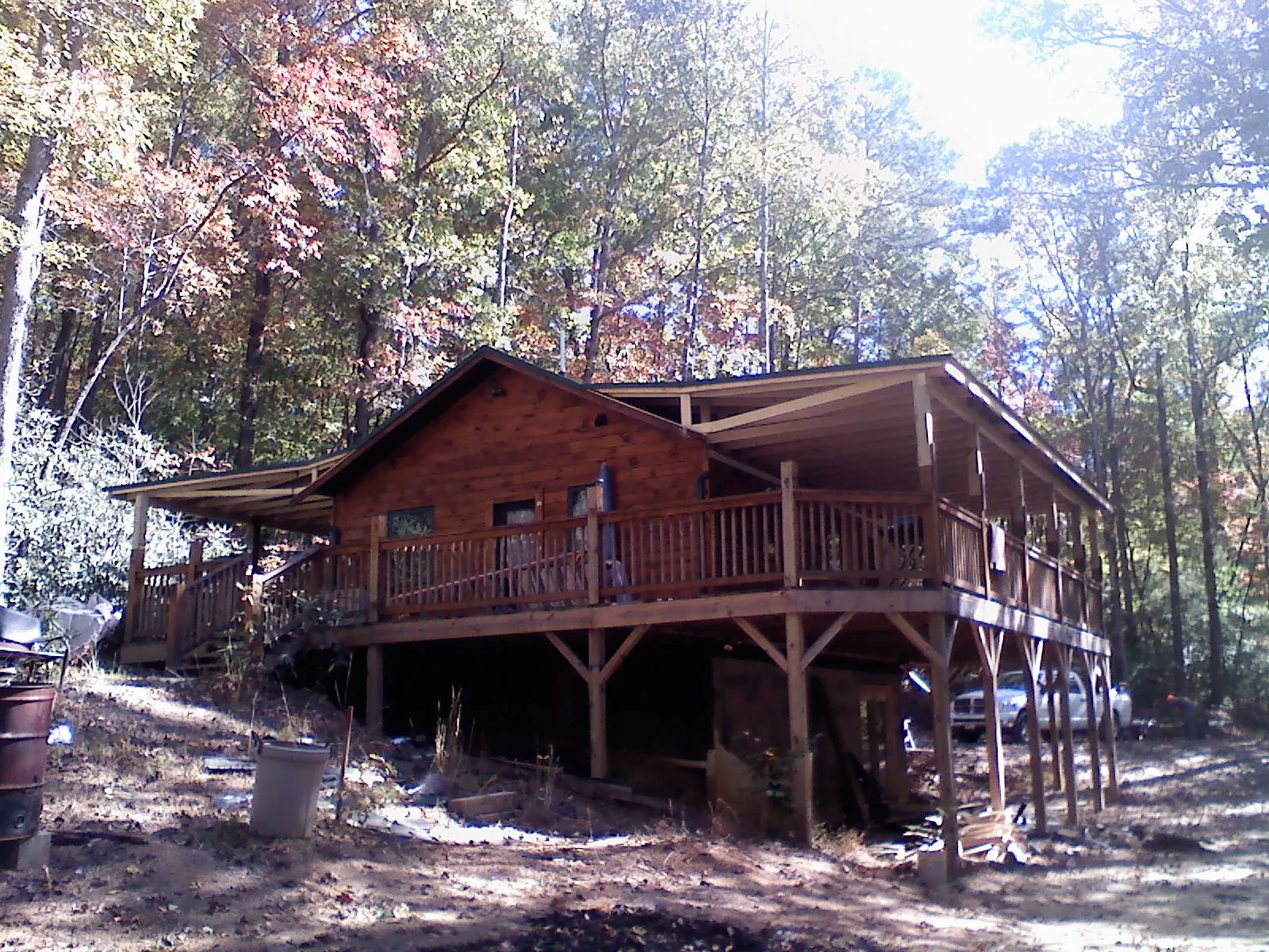 Log cabin with a wraparound porch and metal roof in the fall in Flourtown