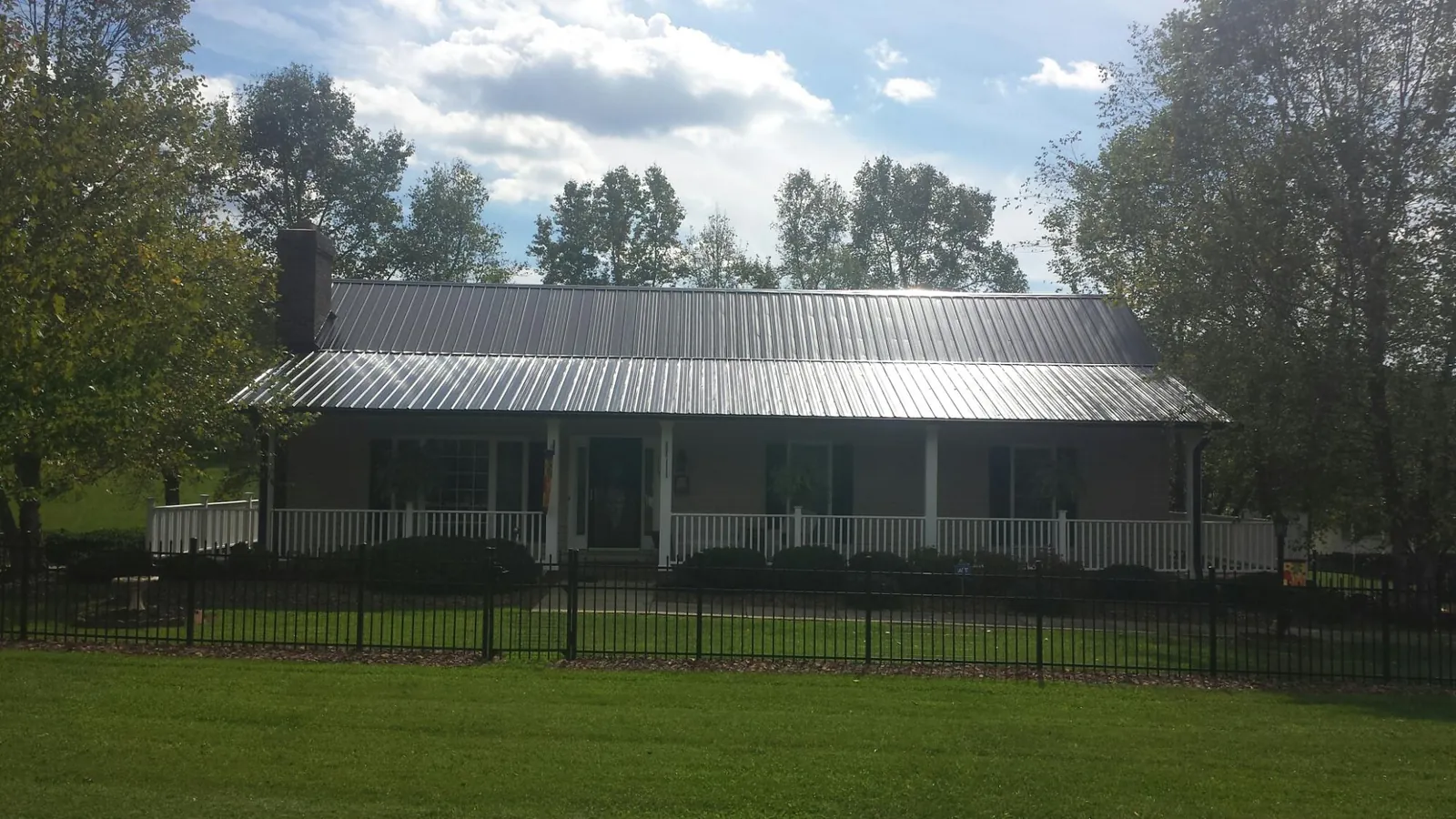 Gray metal roof on a brick ranch with a full width front porch — Gutter Guard Installation work by our crew in Flourtown