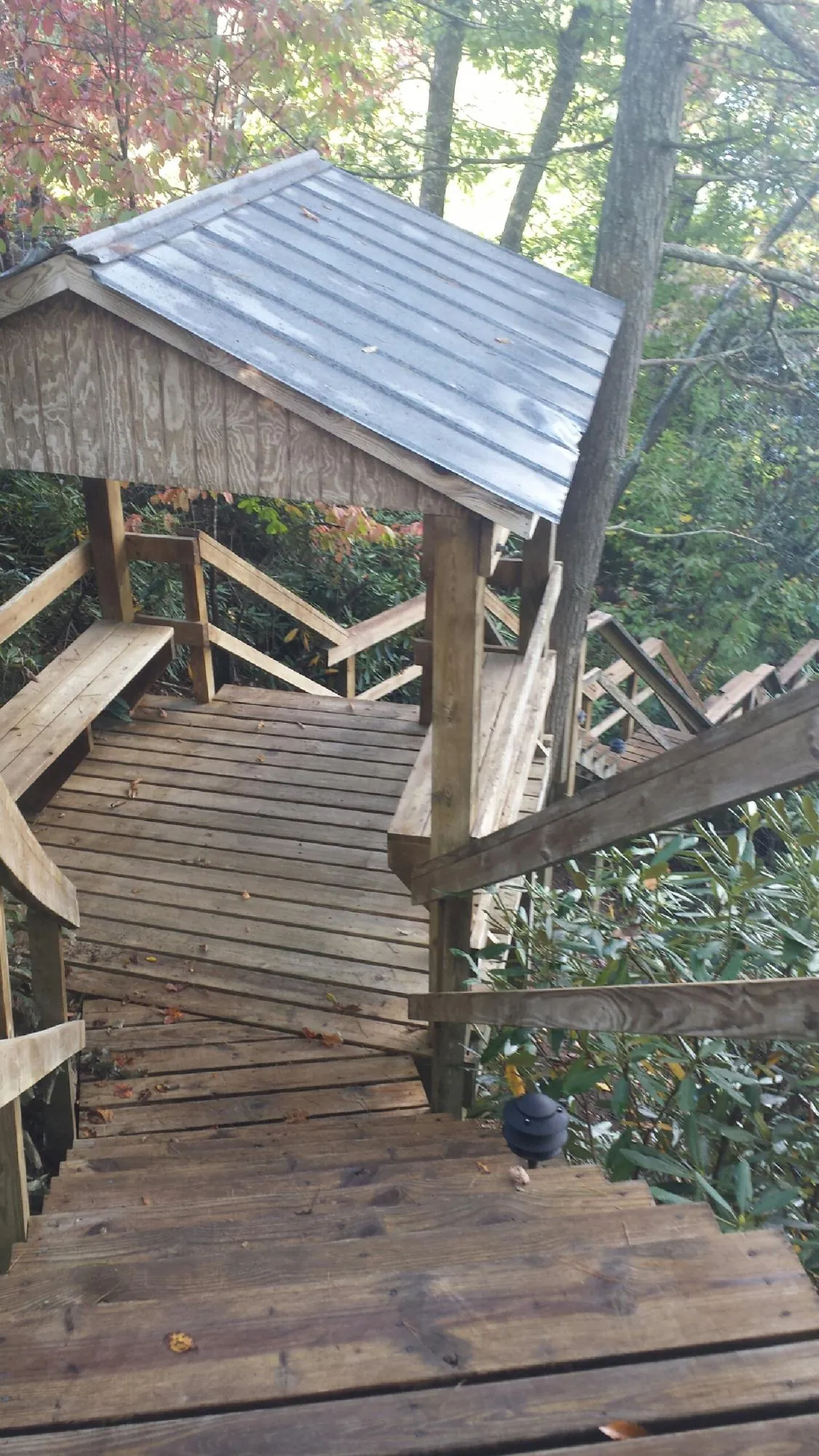 Metal roofed shelter over wooden steps on a wooded walkway — Skylight Repair & Installation work by our crew in Flourtown